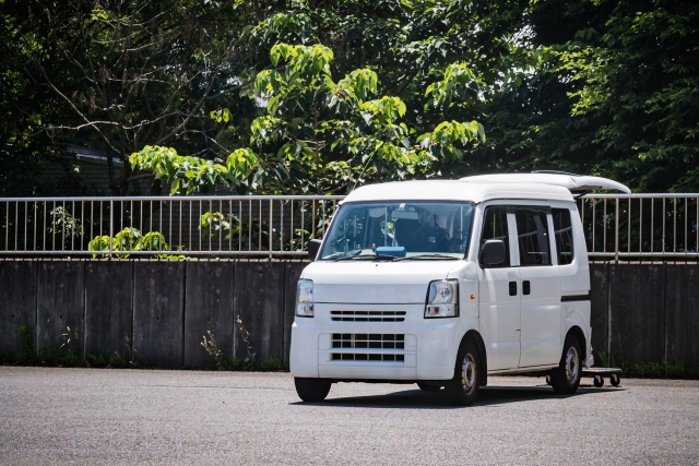 荷物を積み込む白い軽バン